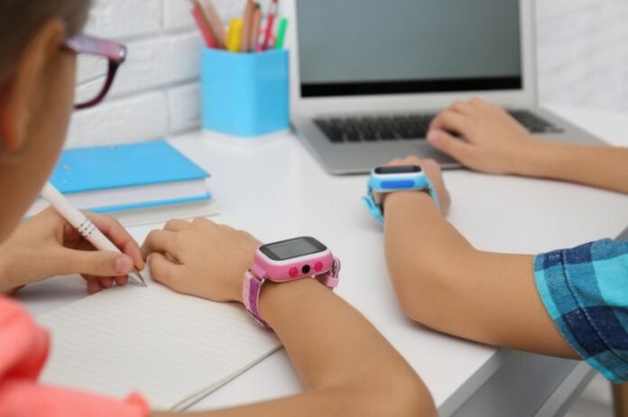 Children wearing smartwatches on their wrists, displaying health monitoring screens.