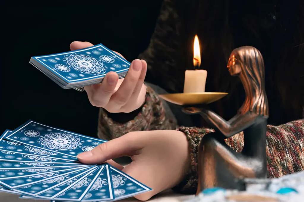 person performing a tarot reading with cards spread out for tarot readings for health insights, accompanied by a candle and a figurine