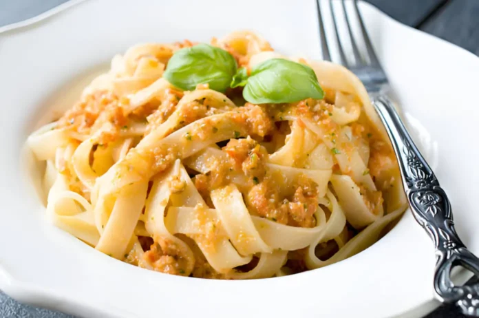 A plate of freshly made Italian pasta topped with a rich tomato sauce and garnished with basil leaves